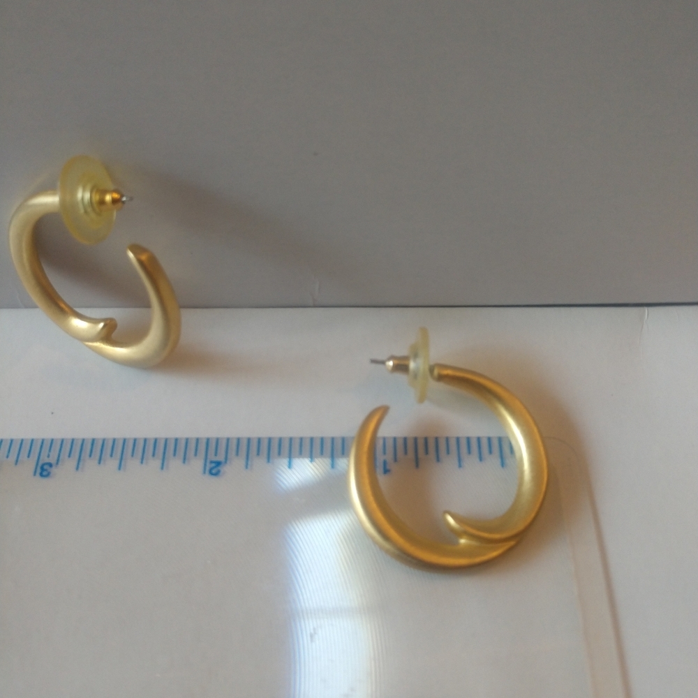 Golden hoop earrings with a double flair in each hoop.